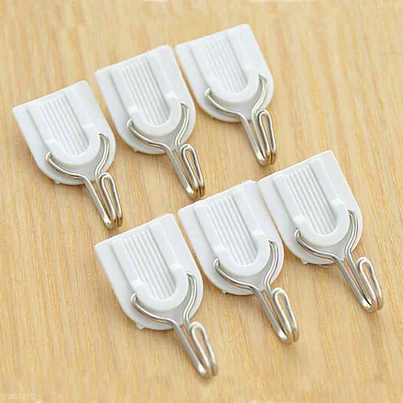 Self-adhesive hook blending seamlessly on a white tiled bathroom wall.